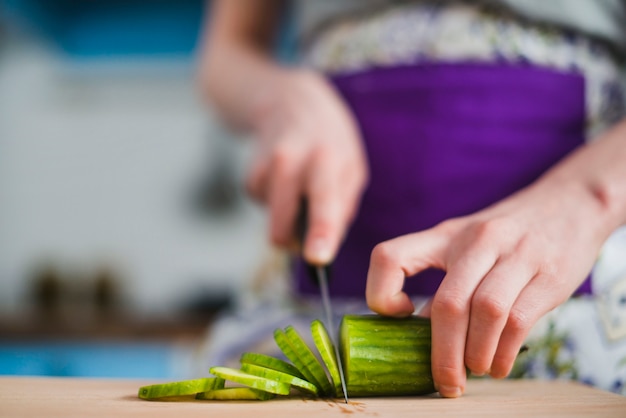 Mujer de cultivo cortando pepino