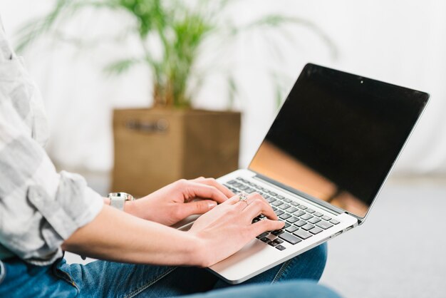 Mujer de cultivo escribiendo en la computadora portátil