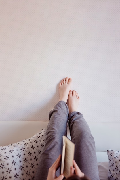 Mujer de cultivo leyendo en la cama