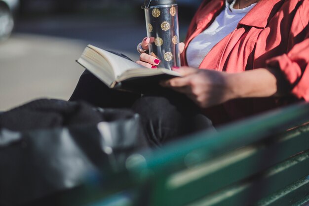 Mujer de cultivo con libro y taza