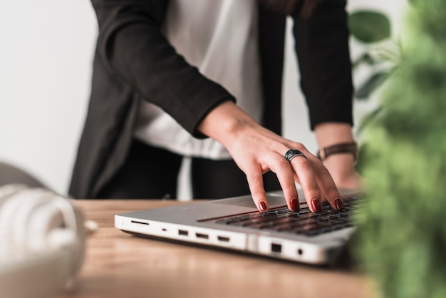 Mujer de cultivo que trabaja en la computadora portátil