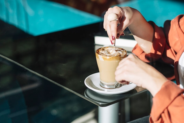 Mujer de cultivo revolviendo el café