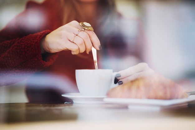 Mujer de cultivo revolviendo el café