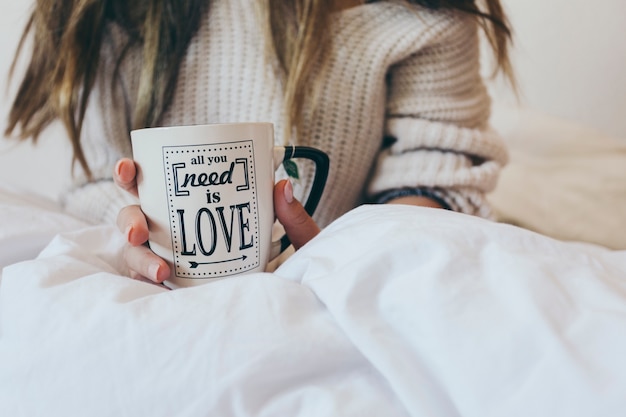 Foto gratuita mujer de cultivo con taza en la cama