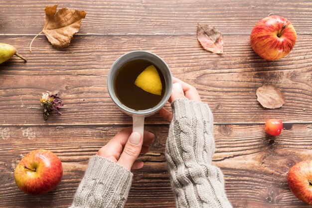 Mujer de cultivo con taza de té de limón