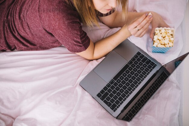 Mujer de cultivo viendo la película en la computadora portátil