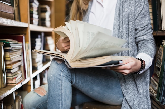 Mujer de cultivo volteando las páginas del libro