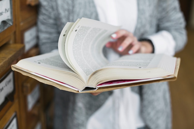 Mujer de cultivo volteando páginas del libro