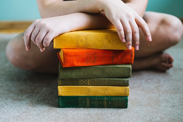 Foto gratuita mujer de cultivos cerca de la pila de libros