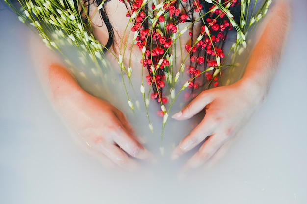 Mujer de cultivos con flores en el agua