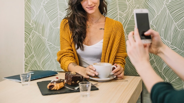 Mujer de cultivos posando para la foto en el café