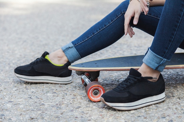 Mujer de cultivos sentado en longboard