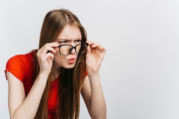 Mujer curiosa con gafas mirando con espacio de copia