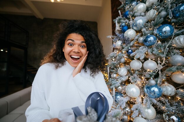 La mujer le da un regalo a su amigo en la cámara.