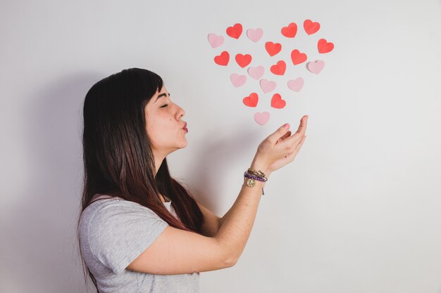 Mujer dando un beso a corazones