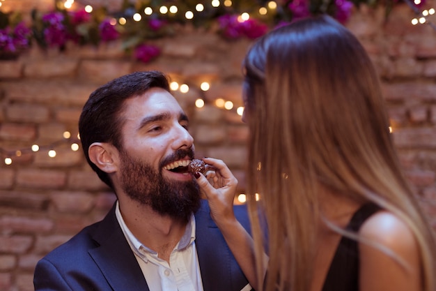 Mujer dando dulce a hombre sonriente