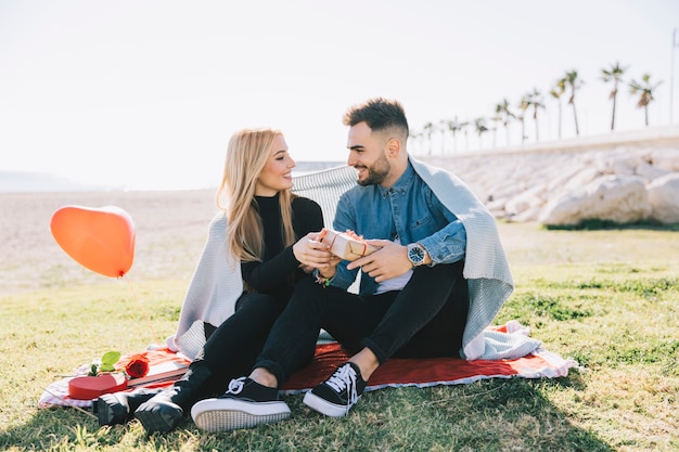 Foto gratuita mujer dando presente al hombre en picnic