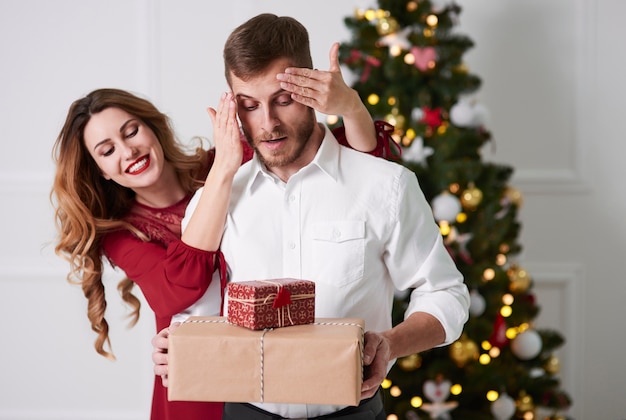 Mujer dando regalos al hombre sorprendido