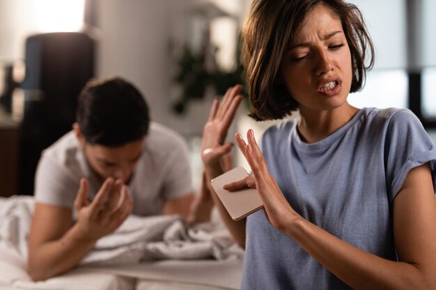 Mujer decepcionada discutiendo con su novio y negándose a escuchar sus explicaciones en casa