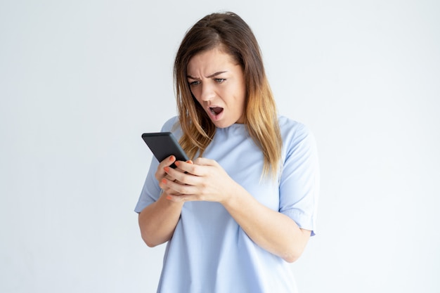 Mujer decepcionada mirando la pantalla del teléfono inteligente