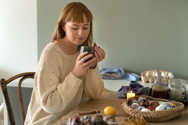 Foto gratuita mujer decorando huevos de pascua