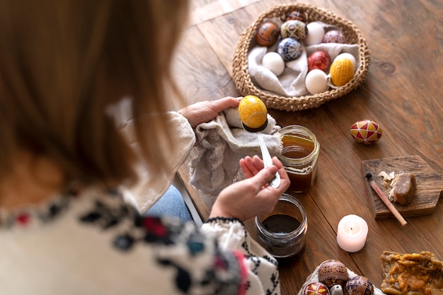 Foto gratuita mujer decorando huevos de pascua