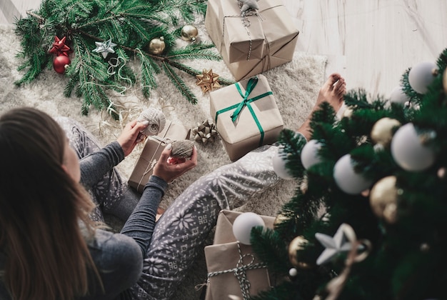 Mujer decorando un regalo de Navidad