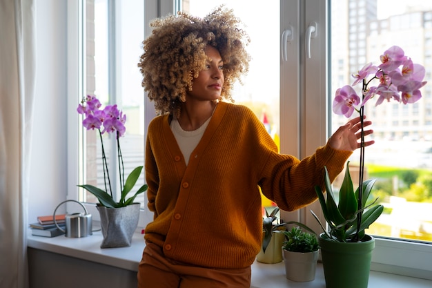 Foto gratuita mujer decorando su casa con orquídeas