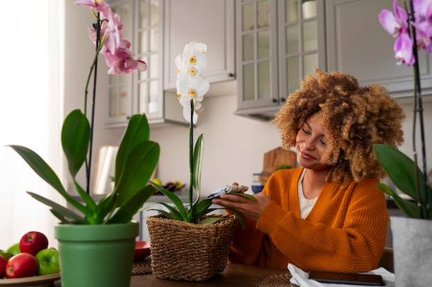 Foto gratuita mujer decorando su casa con orquídeas