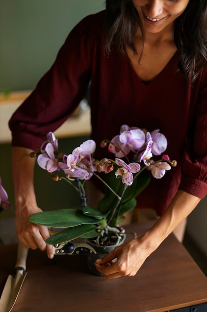 Mujer decorando su casa con orquídeas