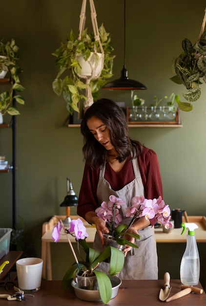 Foto gratuita mujer decorando su casa con orquídeas