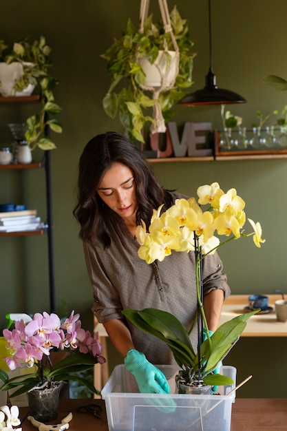 Foto gratuita mujer decorando su casa con orquídeas