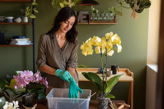 Foto gratuita mujer decorando su casa con orquídeas