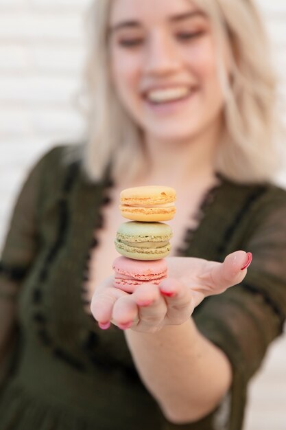 Mujer Defocused con macarons y sonriendo