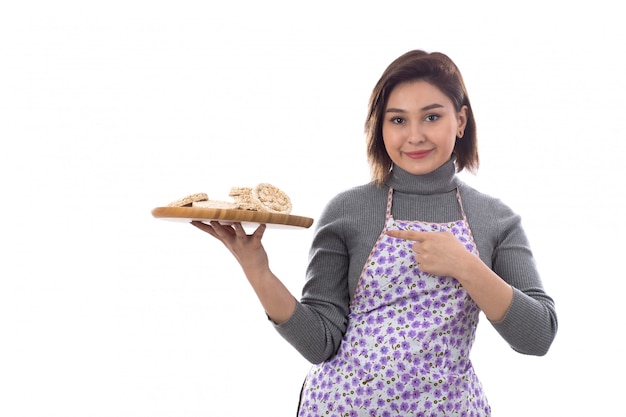 Mujer con delantal morado con galletas