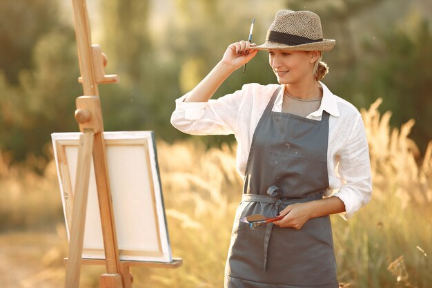Mujer en un delantal pintando en un campo