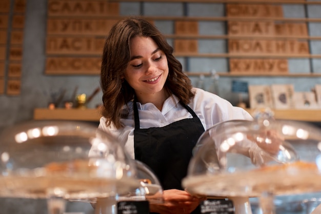 Foto gratuita mujer en delantal trabajando en cafetería