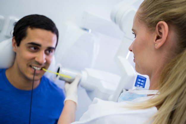 Mujer dentista tomando radiografías de dientes de pacientes