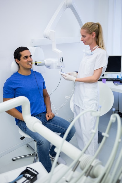 Mujer dentista tomando radiografías de dientes de pacientes