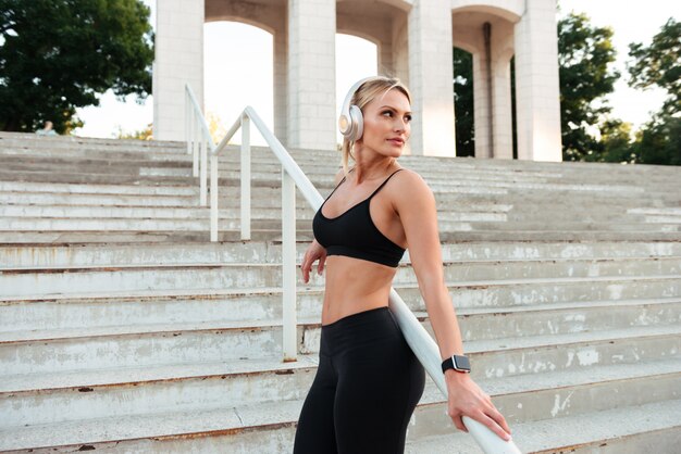 Mujer de deportes joven fuerte concentrada escuchando música