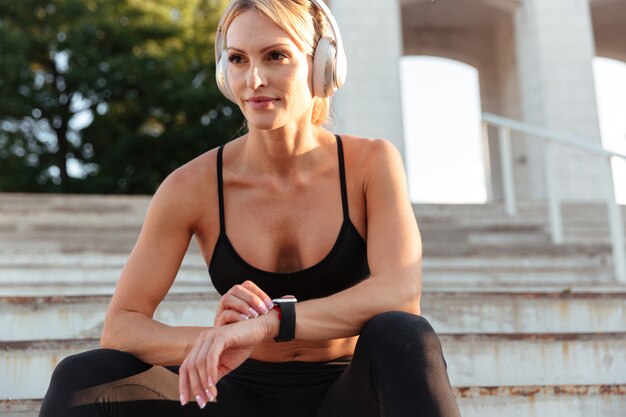 Mujer de deportes joven fuerte concentrada escuchando música