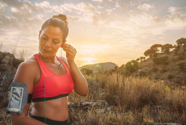 Mujer deportista con auriculares en la naturaleza