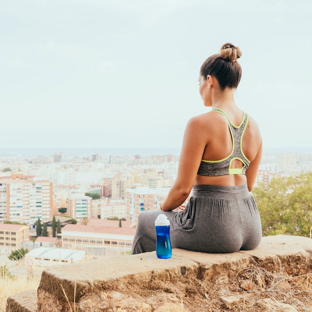 Foto gratuita mujer deportista, botella de agua y la ciudad