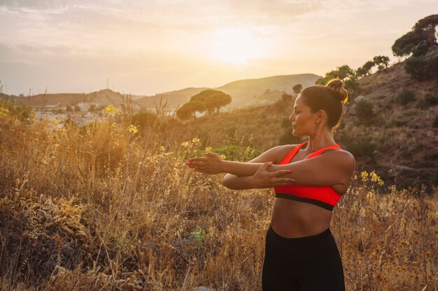 Mujer deportista estirando con paisaje bonito