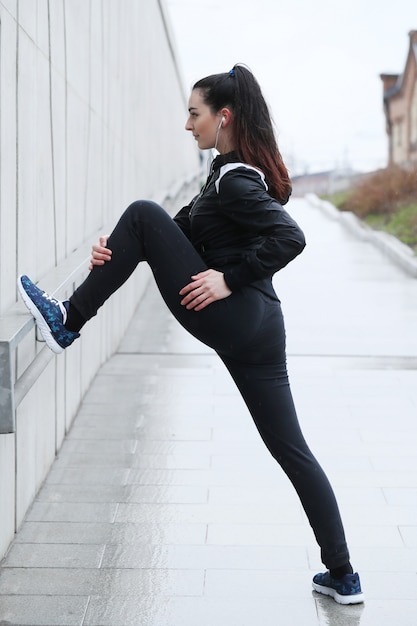 Mujer deportista haciendo estiramientos en la calle