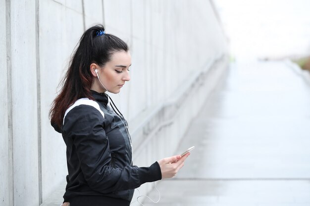 Mujer deportista mirando su teléfono inteligente