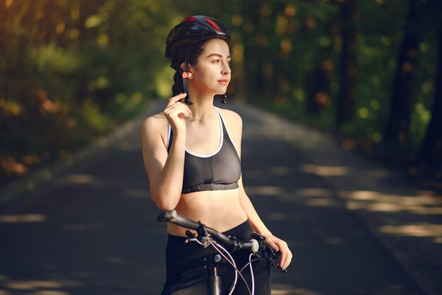 Mujer deportiva andar en bicicleta en el bosque de verano