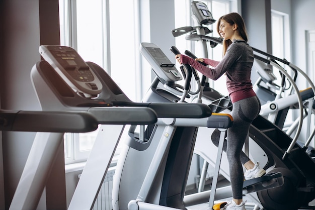 Foto gratuita mujer deportiva ciclismo en orbitrek en el gimnasio