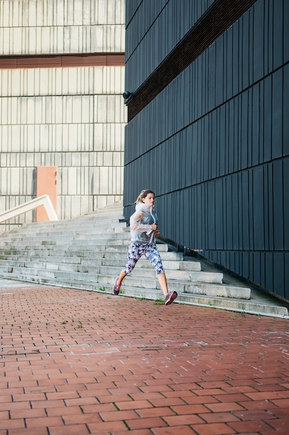 Mujer deportiva corriendo en entorno urbano