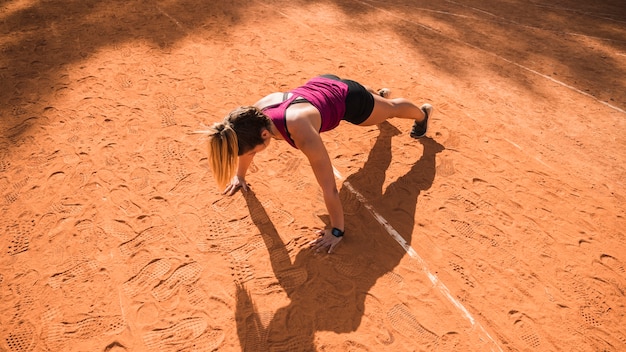 Mujer deportiva entrenando en pista de estadio